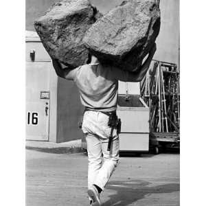 Movie Propman Carrying Two Large Rubber Rocks on Lot at Universal City 