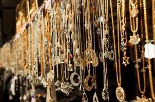 seemingly endless collection of gold necklace pendants hanging in an 