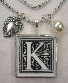   initial k within a frame of cherubs roses on one side a black white